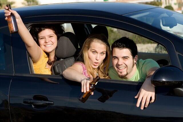 People in a car with beer bottles